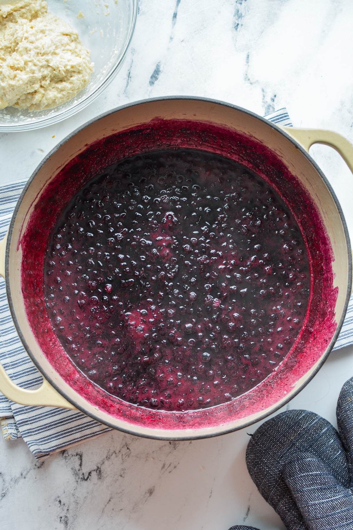 A Dutch Oven filled with stewed blueberries.