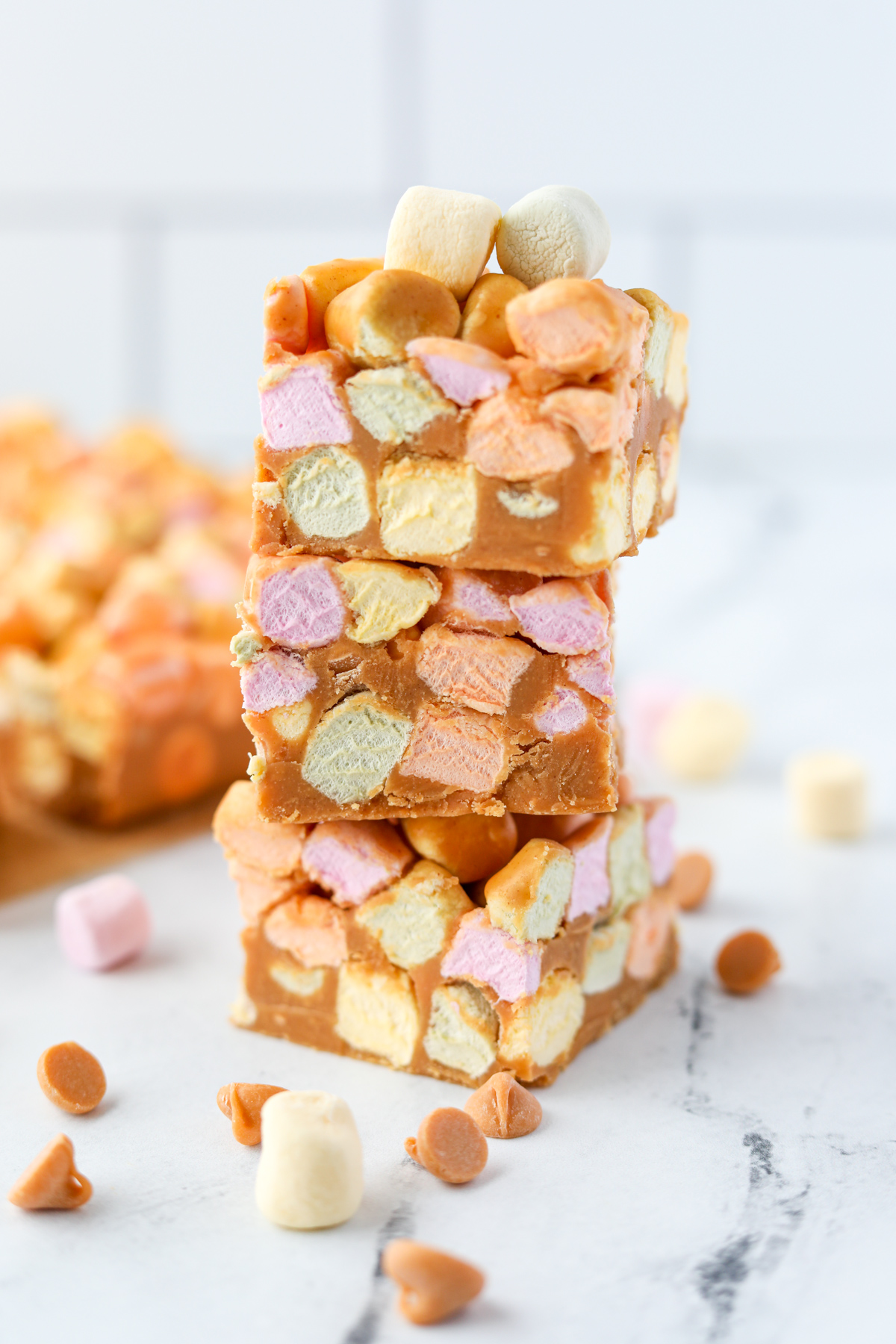 A stack of three colorful marshmallow and peanut butter bars.