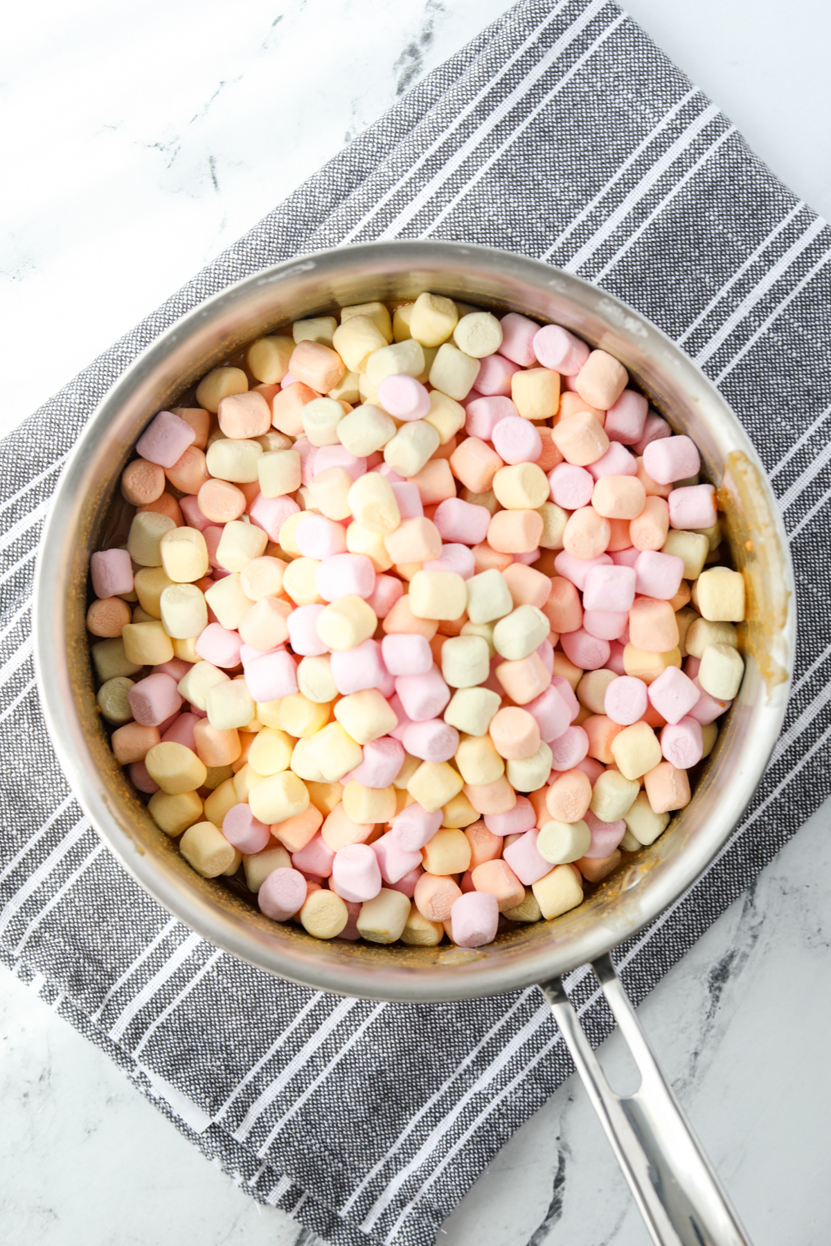 A saucepan with rainbow marshmallows in it.