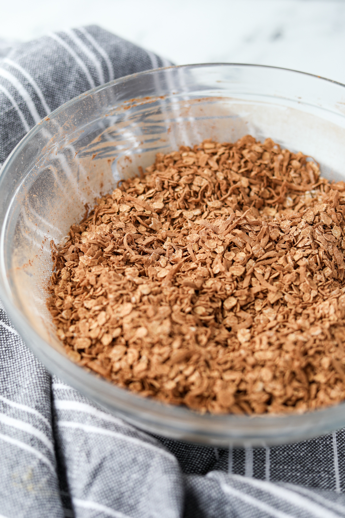 A bowl of oats and coconut that has been coated with cocoa powder.