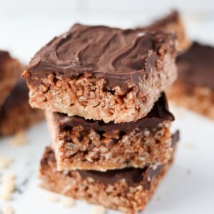 A stack of three Mars Bar squares on top of each other, topped with chocolate.