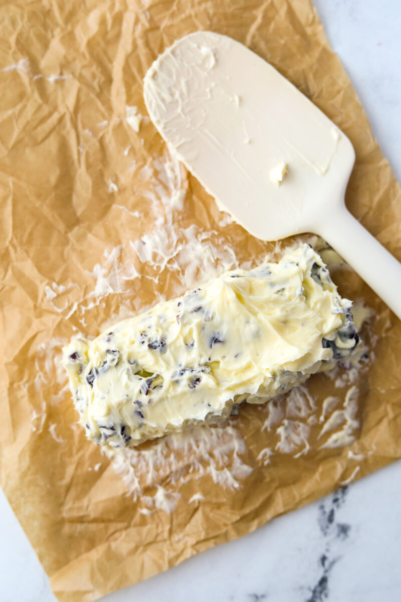 Patting softened seaweed butter into a log on parchment paper.