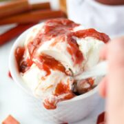 A bowl of ice cream covered in rhubarb sauce.