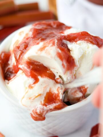 A bowl of ice cream covered in rhubarb sauce.
