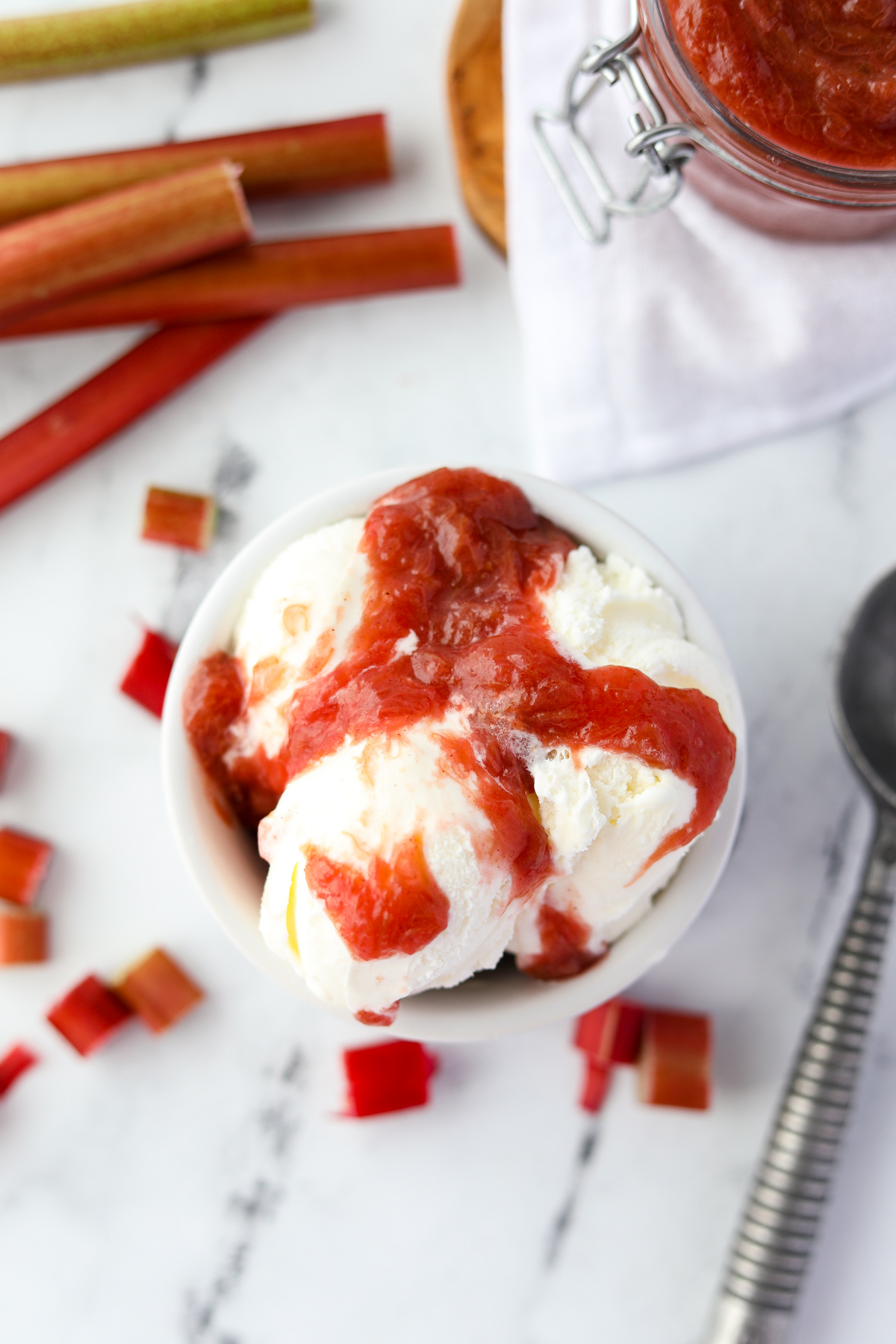 A bowl of ice cream covered with rhubarb sauce.
