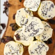 A stack of butter rounds dotted with seaweed flakes.