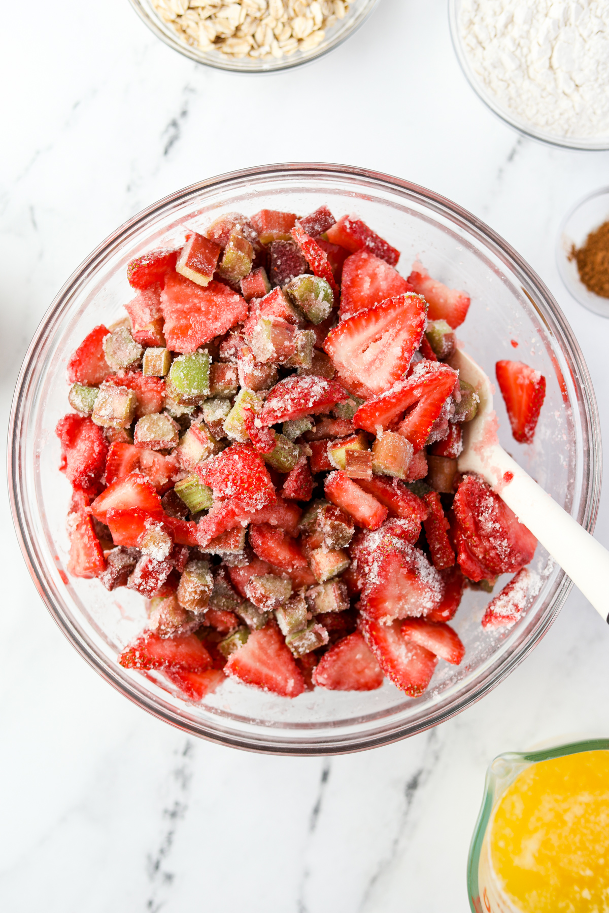 A bowl of strawberries and rhubarb with sugar and flour mixed in.