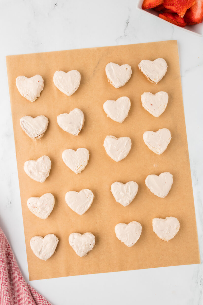 Heart-shaped sandwich pieces on a sheet of parchment paper.