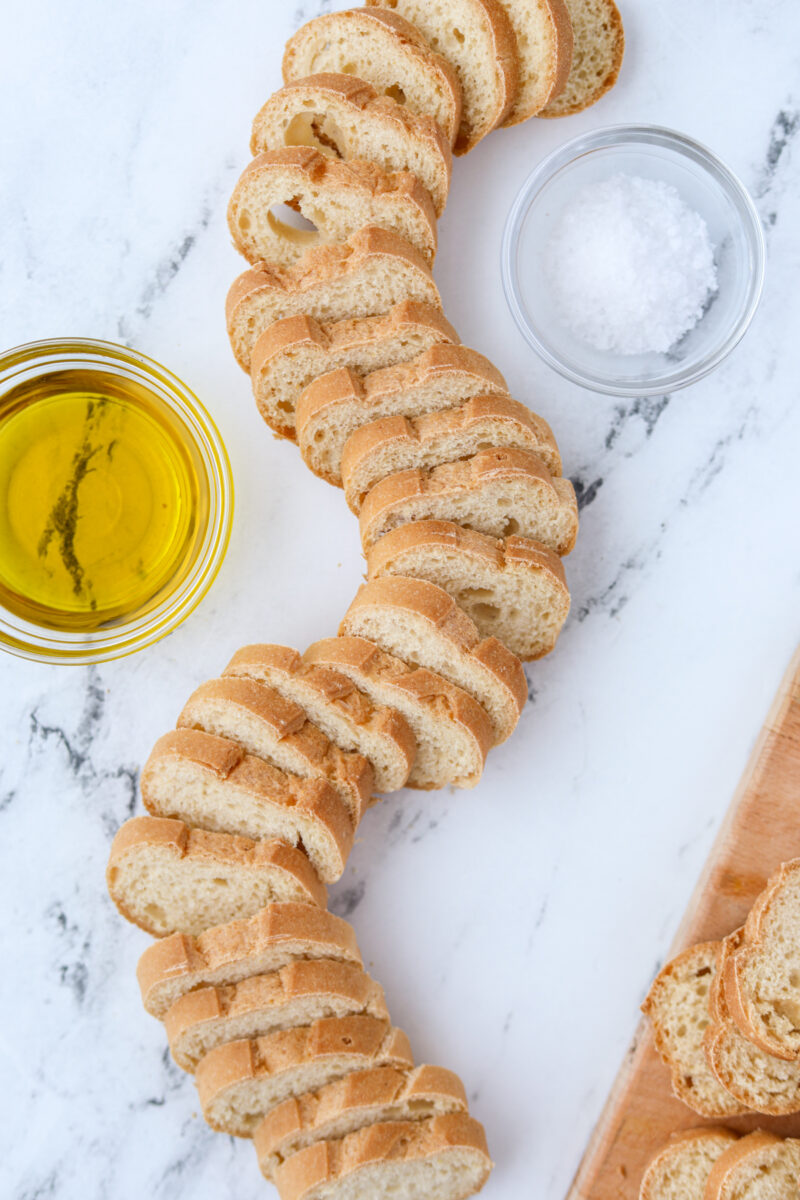 A baguette that's been sliced into thin slices, swirled around on the countertop.