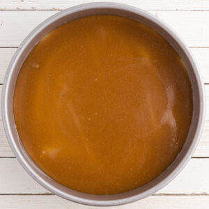 A layer of brown sugar and butter spread into the bottom of a cake pan.