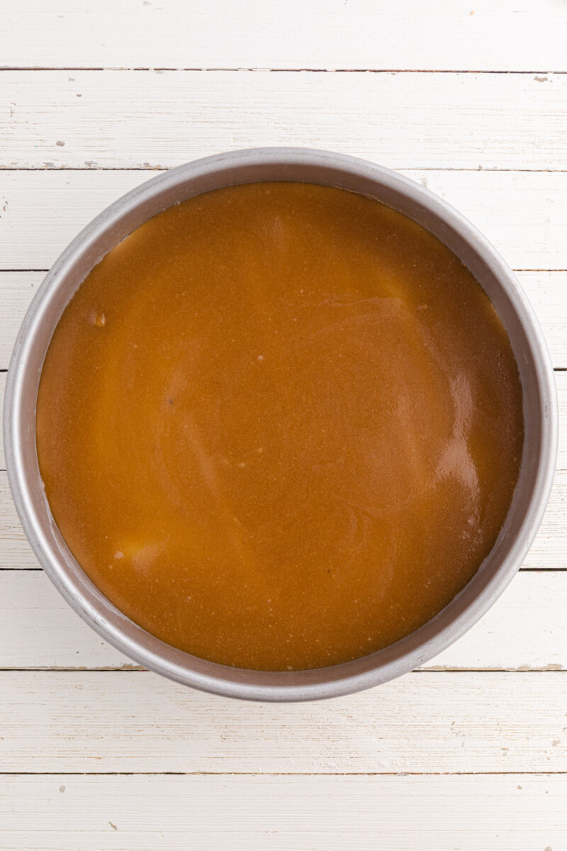 A layer of brown sugar and butter spread into the bottom of a cake pan.